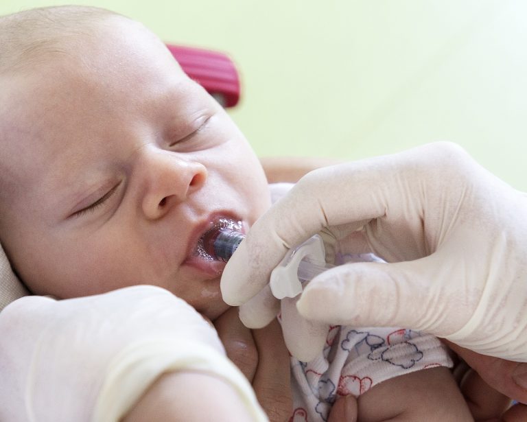 baby receiving vaccine orally