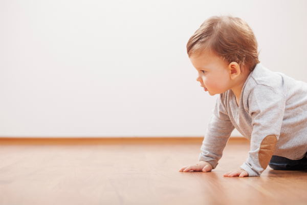 baby crawling on wood floor
