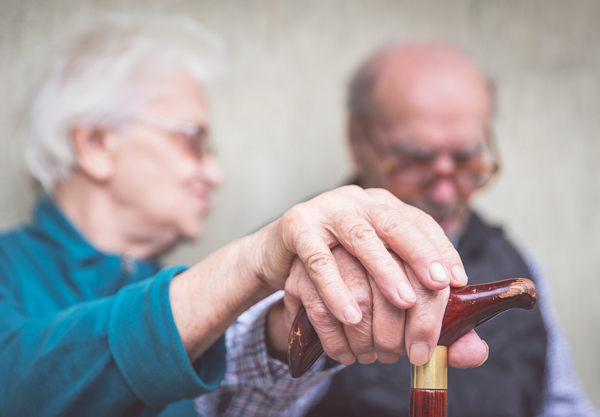 two elderly people holding hands