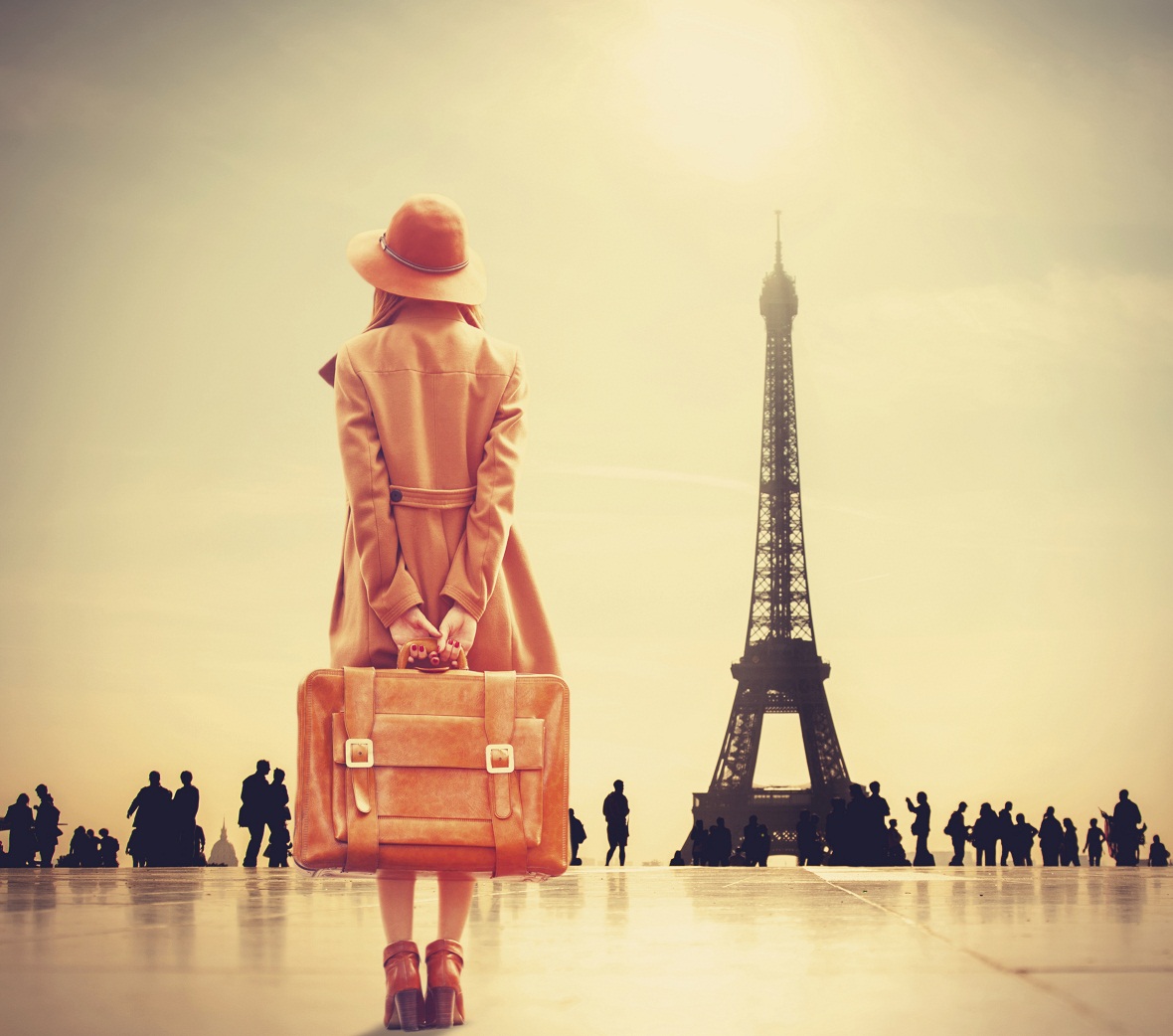 girl with suitcase facing the Eiffel Tower