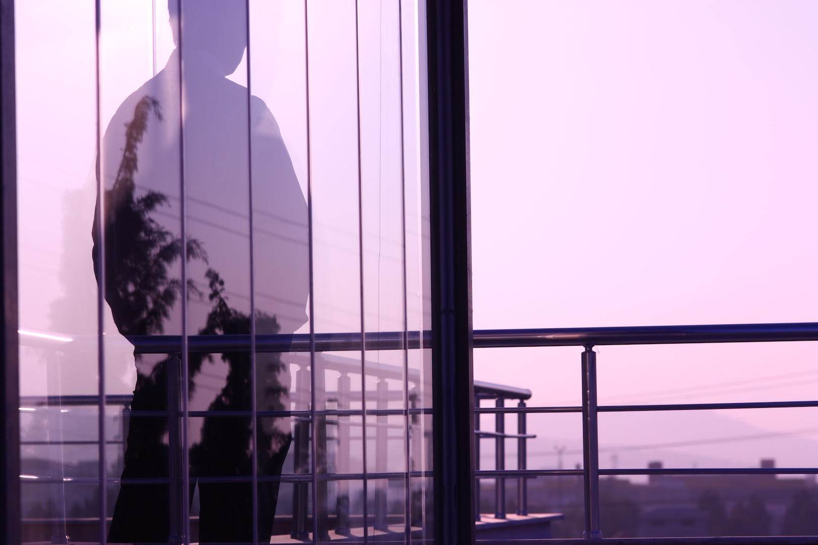 man looking out window of a building