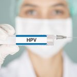 nurse holding up HPV vaccine