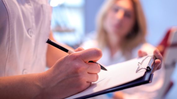 doctor writing on chart as patient looks on CDC Calls for Antiviral Drug Use to Combat Flu