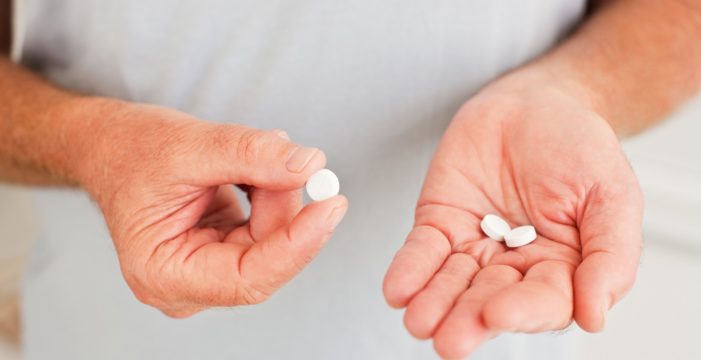 holding three pills Study Reports Daily Aspirin is Not a Magic Bullet