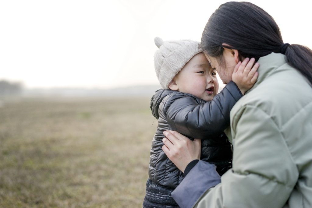 Chinese boy held by mother