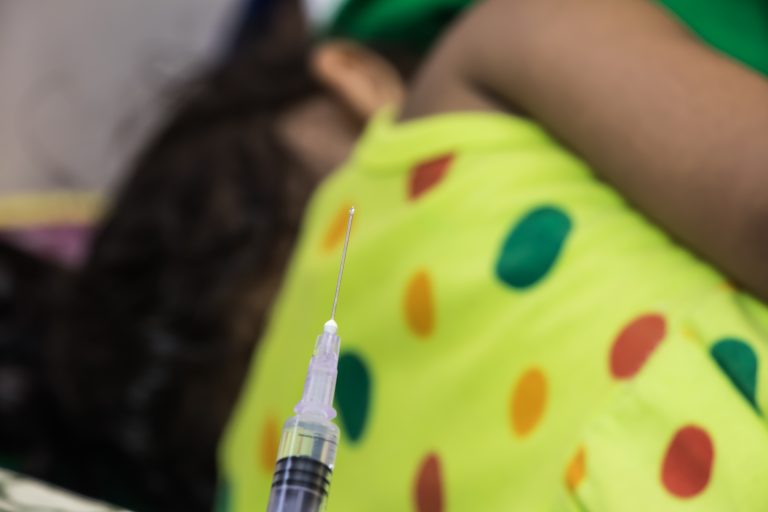 a syringe and a girl in a yellow dress