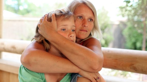 mother holding daughter Vaccine Side Effects ‘Downplayed’ to Boost Vaccine ‘Uptake’?