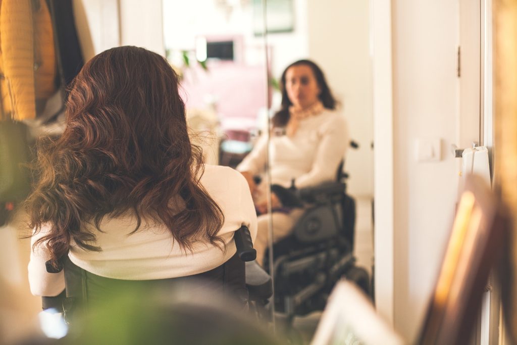 woman in a wheelchair looking at herself in the mirror