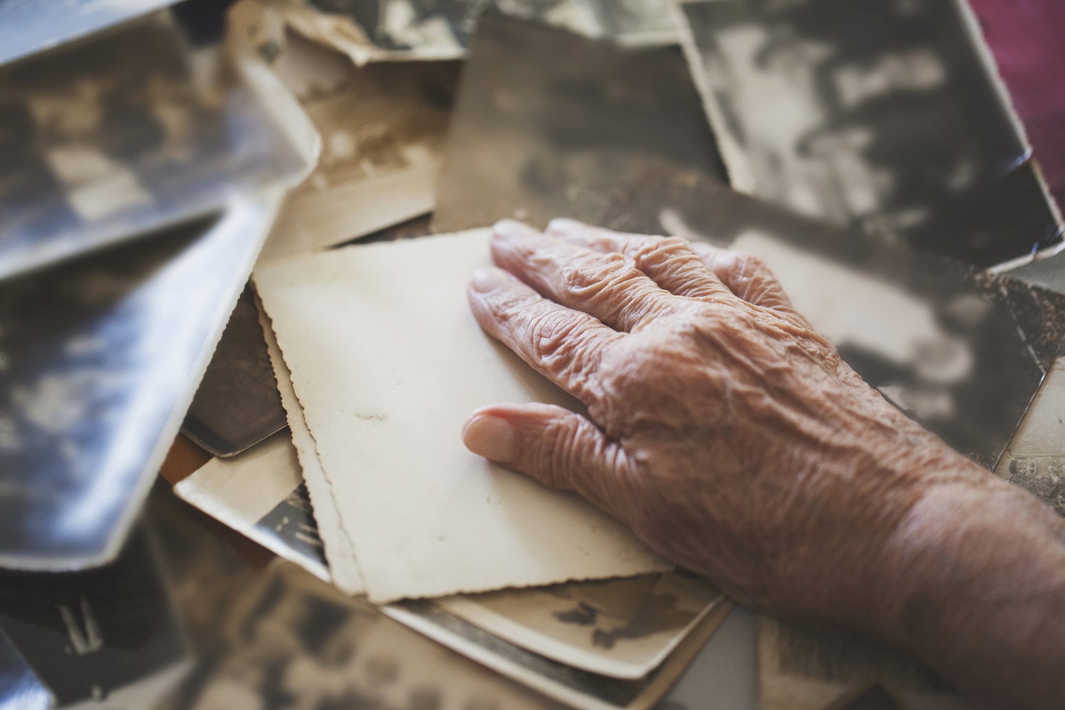 hand of elderly person over old photos