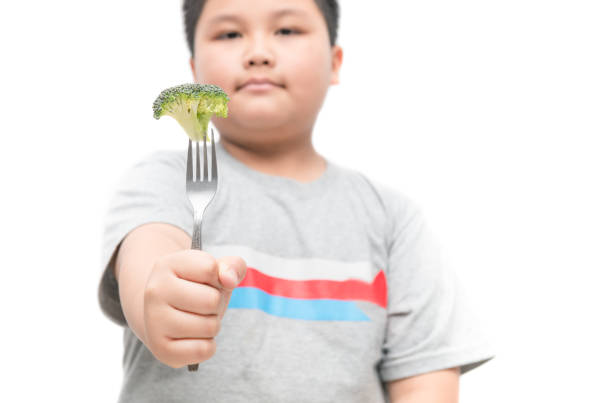 overweight boy holding broccoli