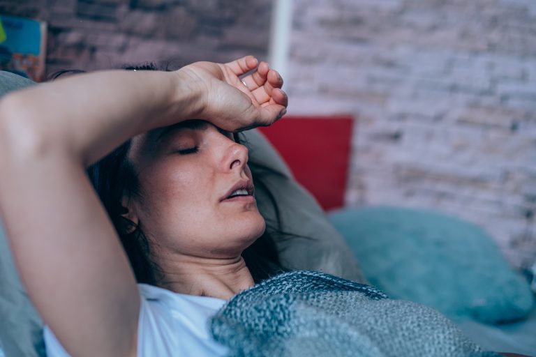 woman lying down with a headache