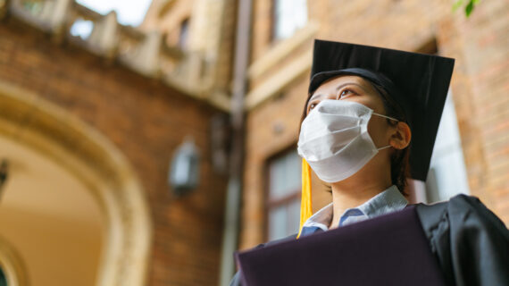 college student in cap and gown Growing Number of Universities Requiring COVID-19 Vaccination