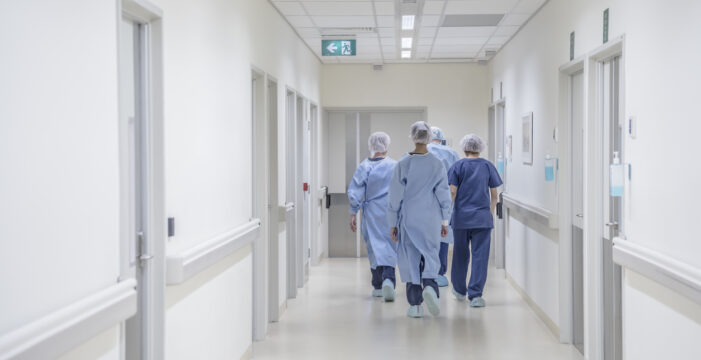 hospital workers walking in hospital 75 Percent COVID-19 Vaccination Rate Among U.S. Hospital Workers