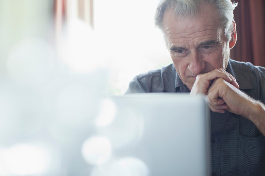 elderly man staring at computer