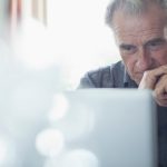 elderly man staring at computer