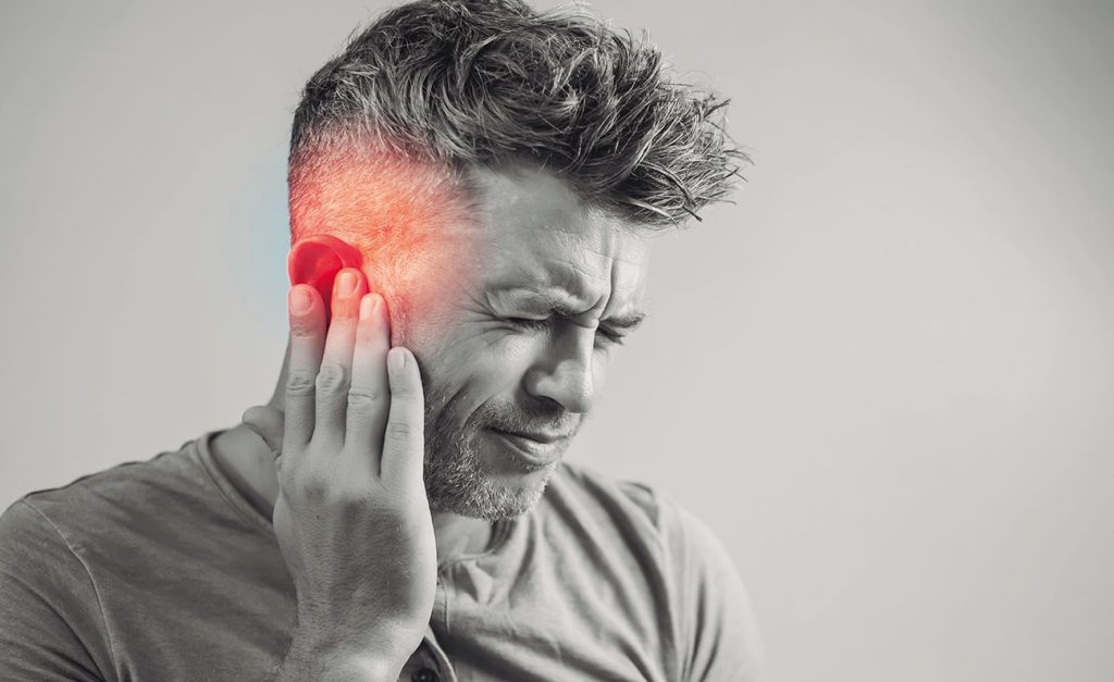 man suffering from tinnitus