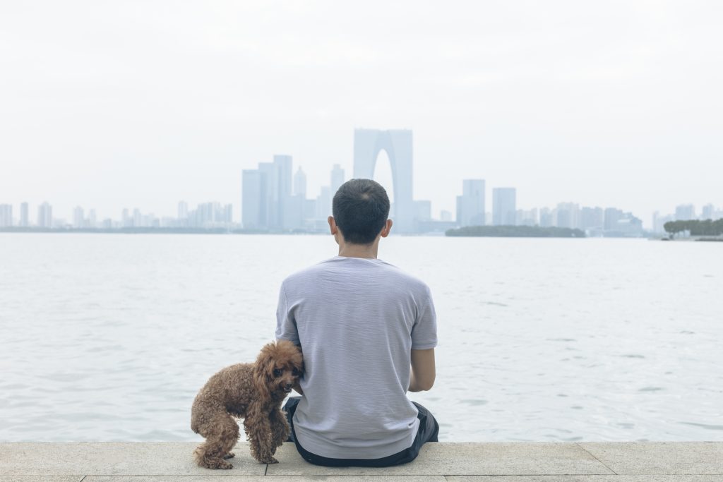 man in China sitting with pet