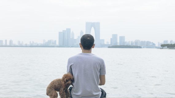 man in China sitting with pet Chinese Officials Kill Pets of Coronavirus Patients, Seal Apartment Complexes
