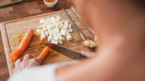 woman cutting carrot Study Finds SARS-CoV-2 Virus Can Survive on Some Food Surfaces