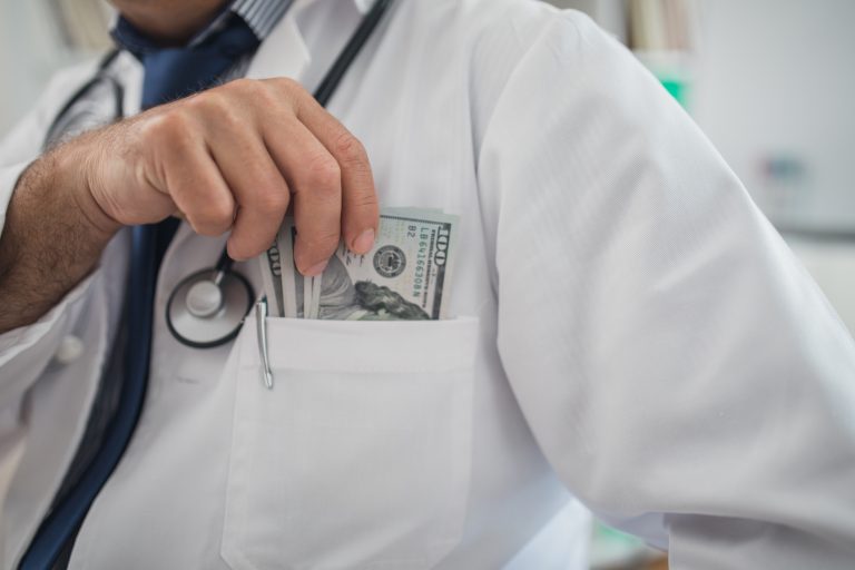 doctor putting cash in pocket