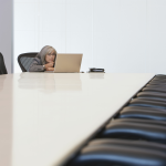 lone woman at conference table