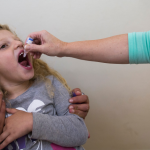 girl gets oral polio vaccine